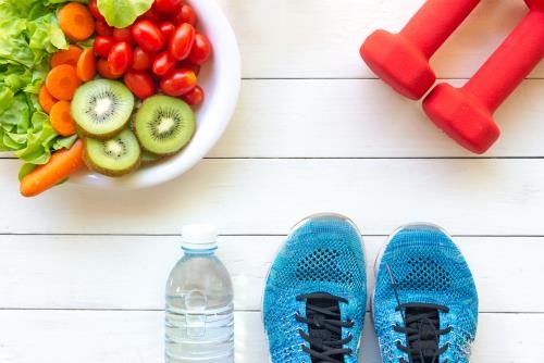 Healthy fruits and vegetables, weights, sneakers and water bottle
