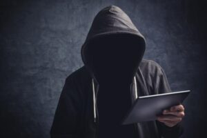 Photo of person wearing a hoodie and holding an ipad. You can't see his face.
