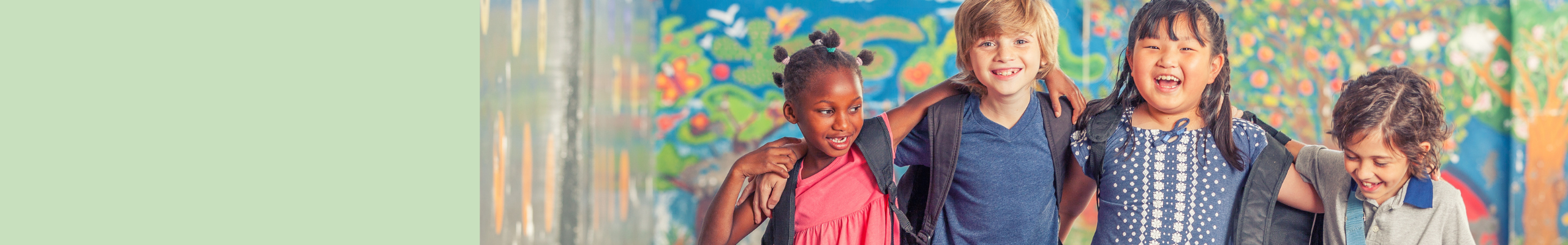 A group of children standing against a paint splattered wall