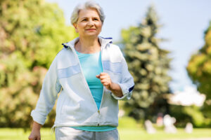 senior woman running along summer park